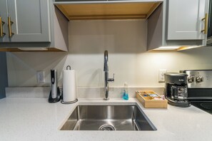 A modern kitchen with a stainless steel sink, a coffee maker, and a paper towel holder. - Industrial Loft  - Nearby Parking Downtown - 2F (Louisville)
