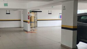 Un'ampia area interna con pavimento piastrellato, una reception e un'auto nelle vicinanze.