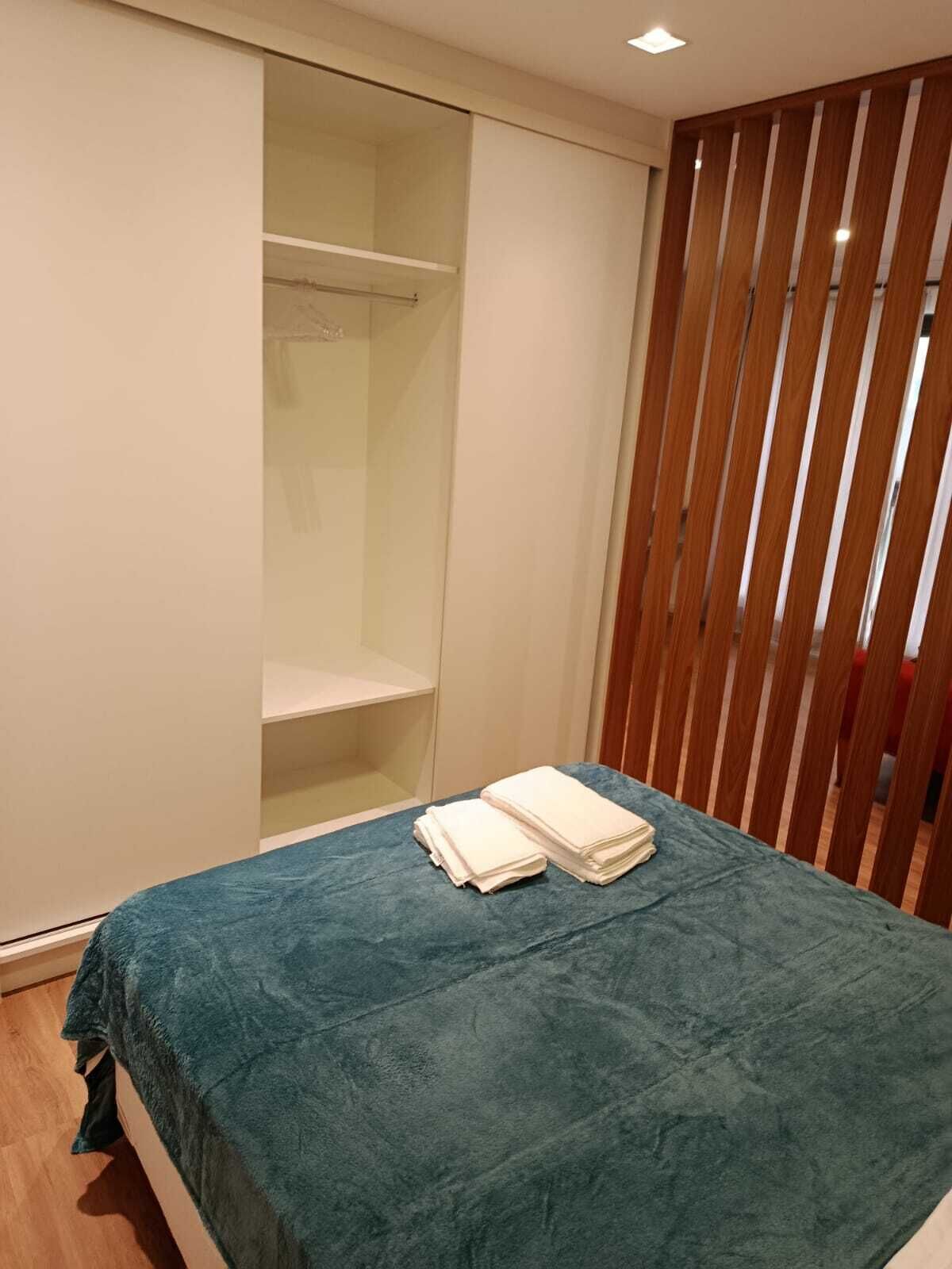 Un dormitorio con cama, armario y puerta corredera.