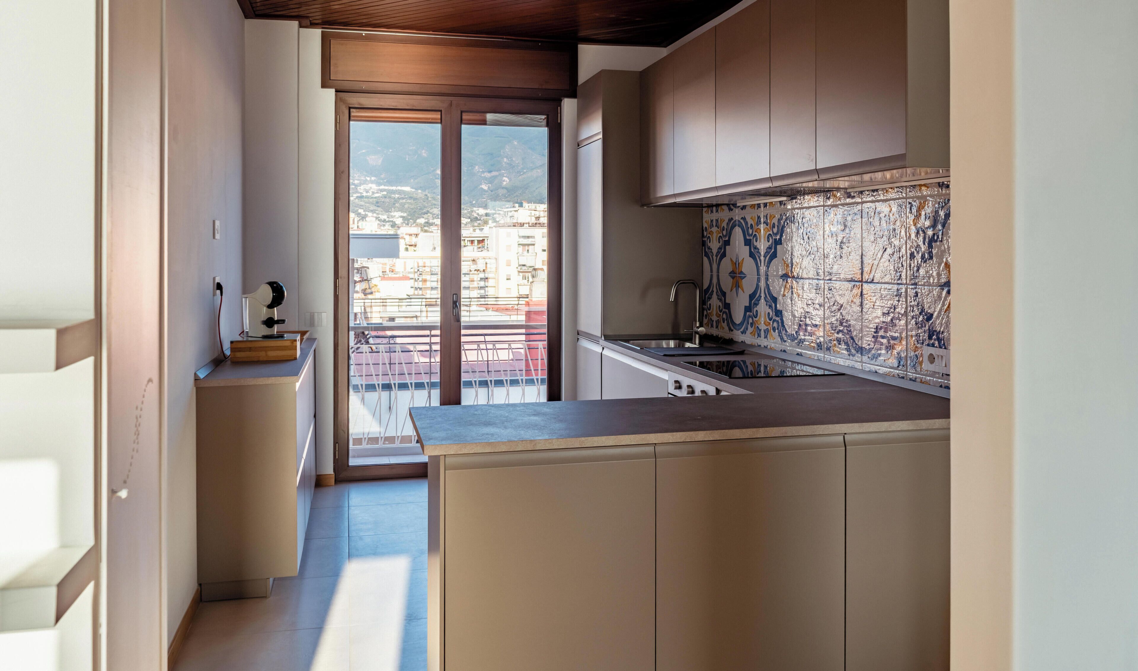 Une cuisine moderne avec vue sur la ville, accessible par une porte coulissante.