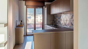 Une cuisine moderne avec vue sur la ville, accessible par une porte coulissante.