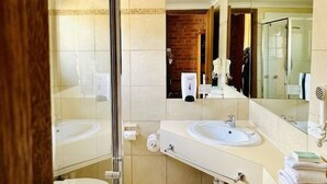A modern bathroom with two sinks, a glass shower enclosure, and a large mirror. - Best Western Early Australian (Mildura)