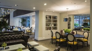 Un salon moderne comprenant un canapé, une table à manger, des chaises et une bibliothèque.