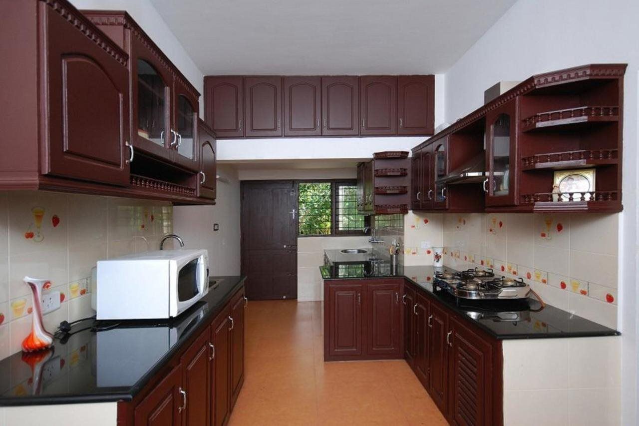 A kitchen with dark wooden cabinets, a white microwave, and a gas stove.