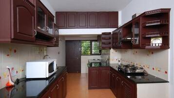 A kitchen with dark wooden cabinets, a white microwave, and a gas stove.