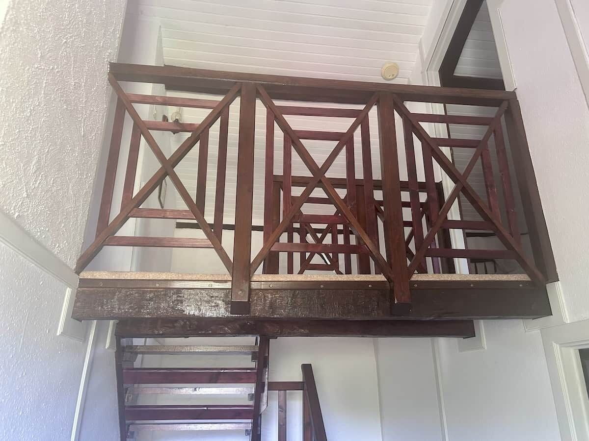 Guarda-corpo de escadas de madeira com design geométrico.