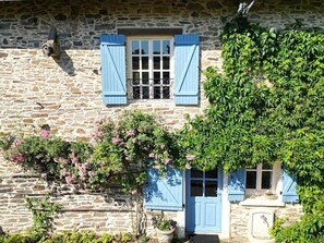 A stone building with blue shutters, a small balcony, and climbing plants. - Storybook Stone Cottage with Private Garden (Oradour-sur-Vayres)