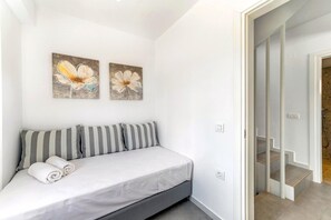 Ein Schlafzimmer mit einem Bett, Kissen und zwei an der Wand hängenden Bildern.
