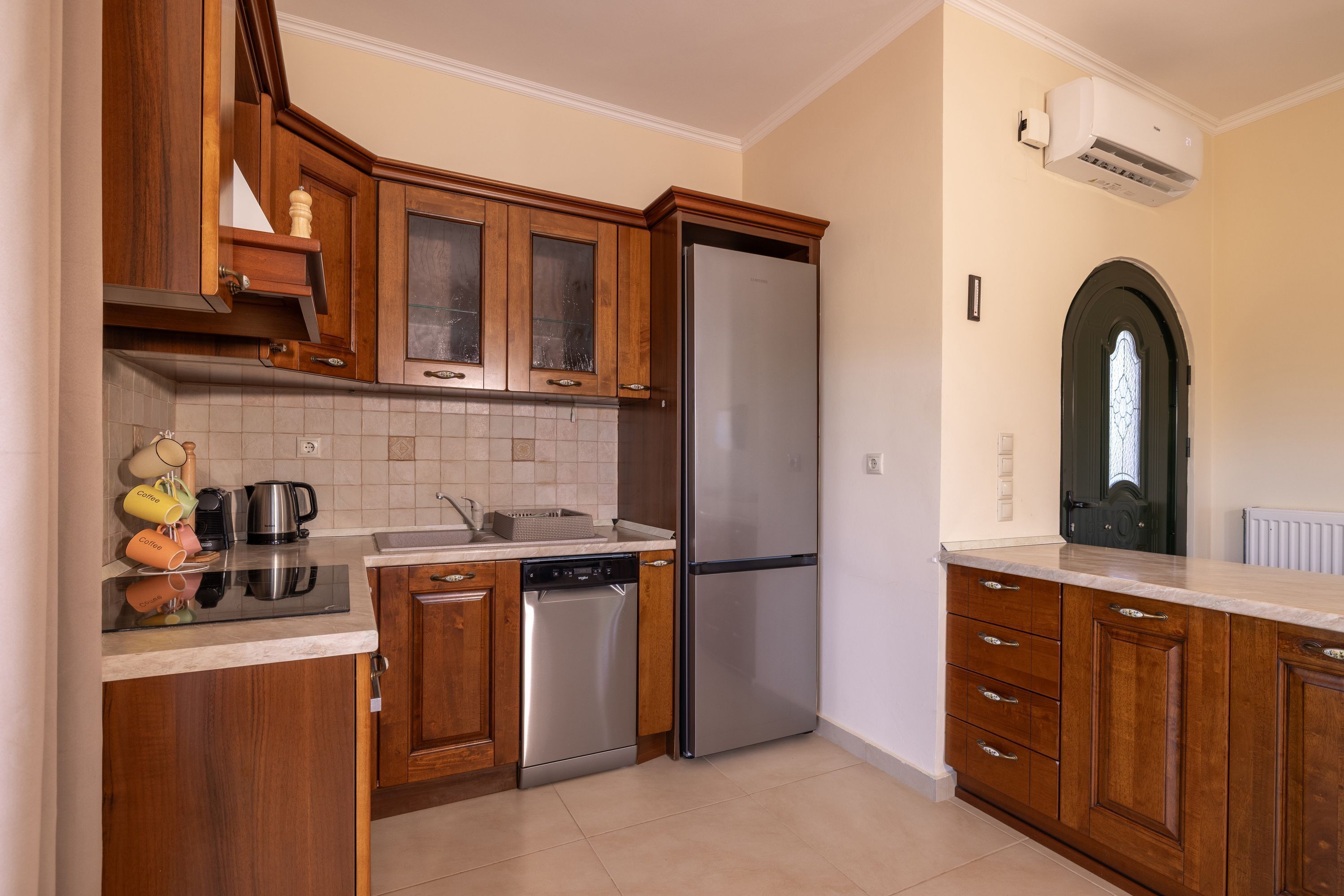 Une cuisine moderne avec des meubles en bois, un réfrigérateur en acier inoxydable et un lave-vaisselle.