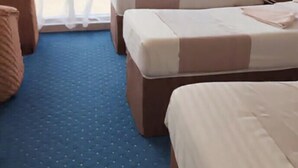 A hotel room with two beds, a large window, and a blue carpet. - Qimmat AlAwali Hotel (Makkah)