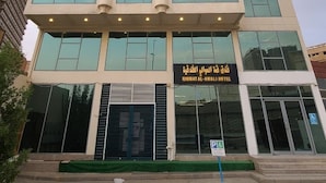 A multi-story hotel with a modern facade, large windows, and a sign indicating it is the Qimatt Al-Awali Hotel. - Qimmat AlAwali Hotel (Makkah)