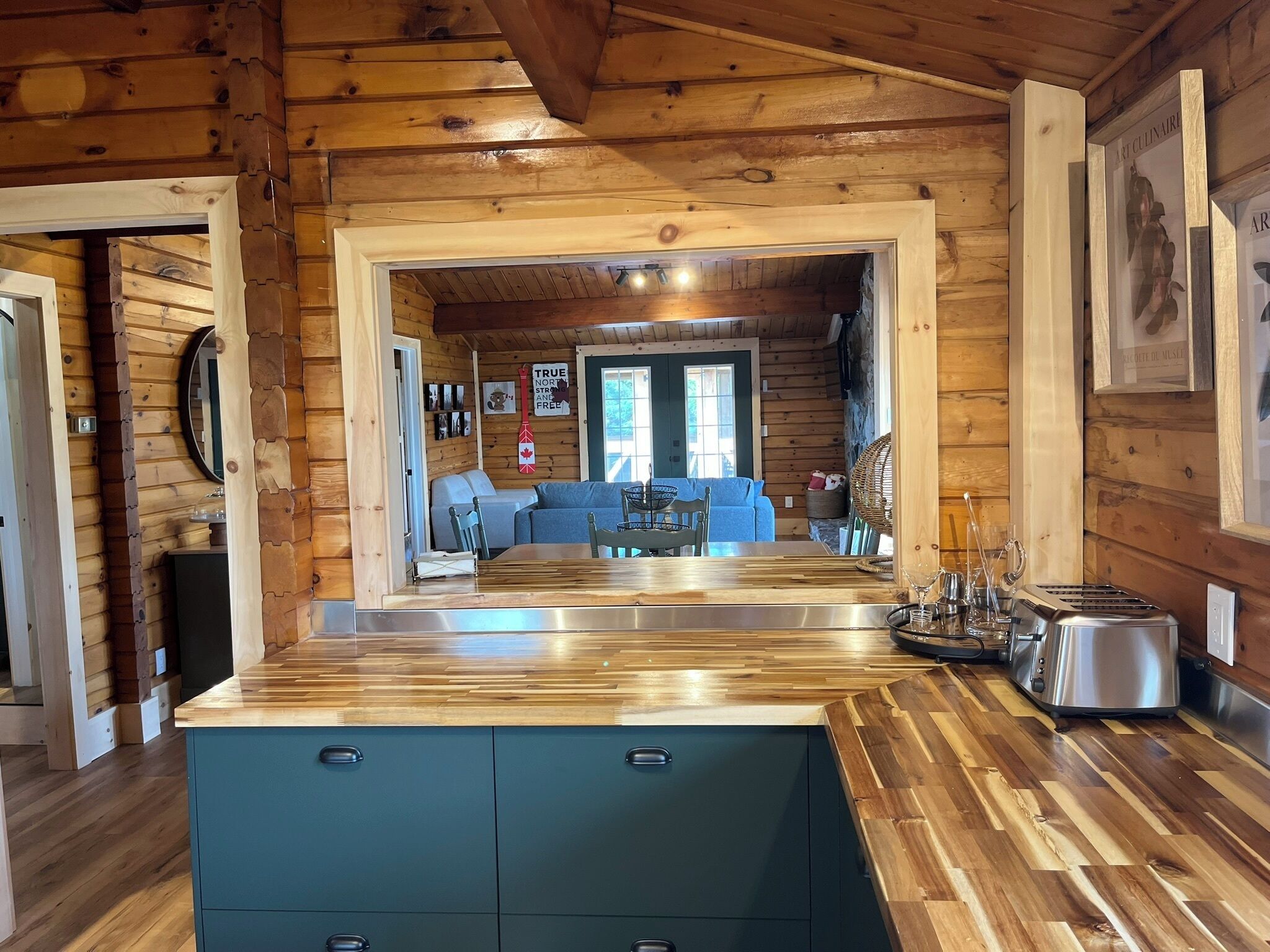 L’intérieur d’un chalet en bois comprend un espace cuisine avec un plan de travail et des placards en bois.