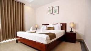 A hotel room with a large bed, two bedside lamps, a nightstand, and a window with curtains. - Mekong View Apartment and Hotel II (Phnom Penh)