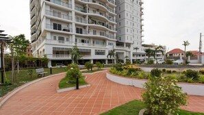 A multi-story residential building with balconies, a paved courtyard, and surrounding greenery. - Mekong View Apartment and Hotel II (Phnom Penh)