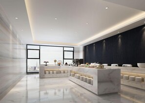 En moderne hotellobby med marmorgulv, en central receptionsdisk og et stort vindue med udsigt over byen.
