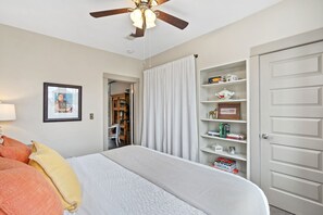 A bedroom with a bed, a ceiling fan, a bookshelf, and a door. - Magnolia Market Loft | Steps to Old Town & Trails (Fort Collins)