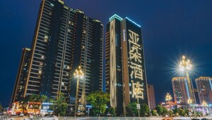 A high-rise building with illuminated signage, a well-lit street, and a clear view of the surrounding urban environment. - Atour Hotel (Taizhou)