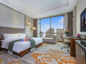 A hotel room with a large bed, a desk, a chair, and a view of the city. - Sport Hotel (Chongqing)