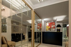 A modern interior with a mirrored closet, a black console table, and a framed artwork on the wall. - Fos Hotel (Athens)