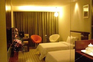 A hotel room with two beds, a desk, a chair, a mirror, and a curtain. - Wanguo International Hotel (Shenzhen)