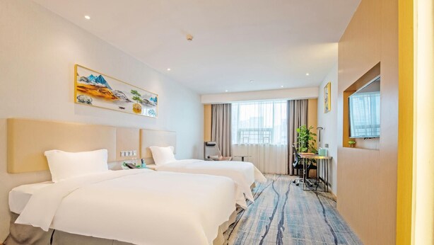 A hotel room with two beds, a desk, a chair, a window with curtains, and a painting on the wall. - Wanguo International Hotel (Shenzhen)