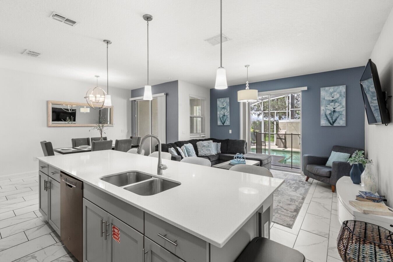 A modern kitchen with a central island, built-in appliances, and pendant lighting.