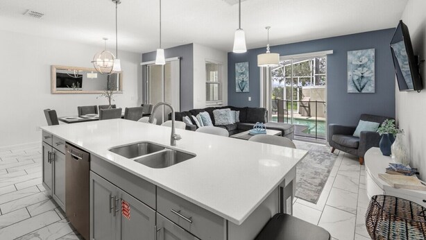 A modern kitchen with a central island, built-in appliances, and pendant lighting. - Pebble Beach Retreat (Kissimmee)