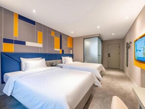 Une chambre d’hôtel avec deux lits, une télévision et un décor mural moderne.
