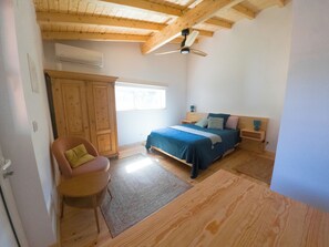 A bedroom with a bed, a chair, a wardrobe, and a ceiling fan. - Studio by the pool (Penela)