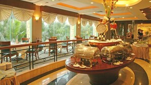 A hotel lobby with a central buffet area, seating arrangements, and a view of the outdoors. - Fangzhong Sunshine Hotel (Dongguan)