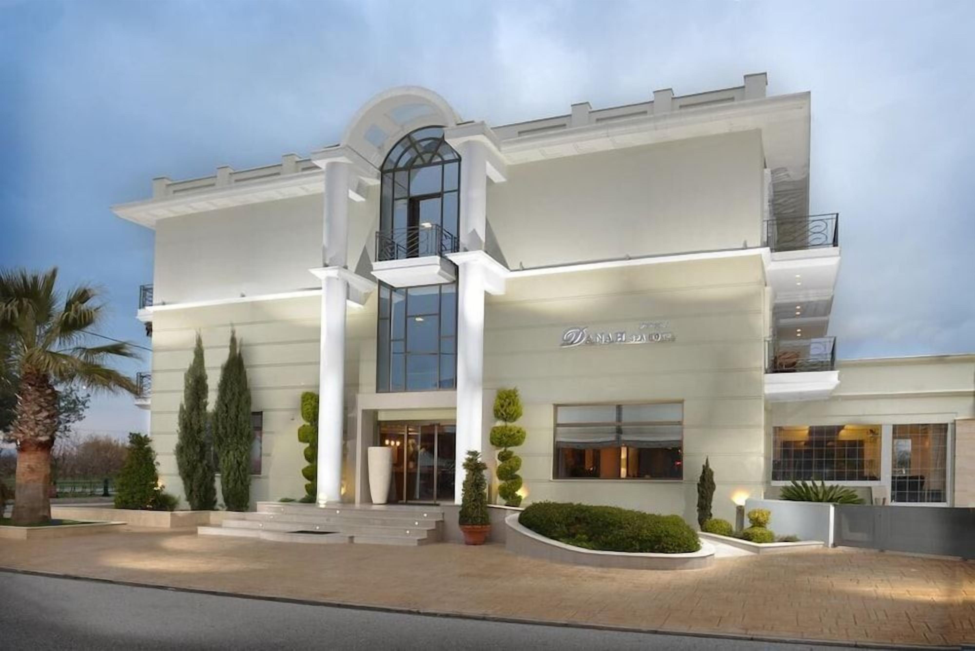 A modern hotel with a symmetrical facade, large windows, and a central entrance.