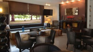 A modern interior with a fireplace, seating area, and a television. - Bomo Danai Hotel (Katerini)