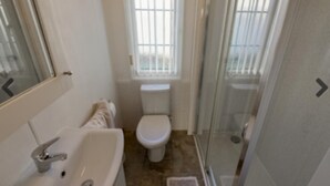 Ein Badezimmer mit Waschbecken, Toilette und Duschbereich.
