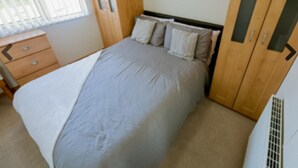 Ein Schlafzimmer mit einem Bett, einem Nachttisch und einem Kleiderschrank.