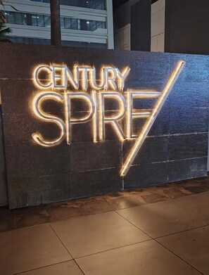 A neon sign with the text 'CENTURY SPREE' on a textured wall. - Spire Skyline Suite | Luxury 45 sqm + Pool, Gym, and Netflix (Makati City)