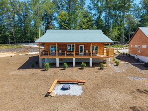A wooden cabin with a balcony, surrounded by trees.
