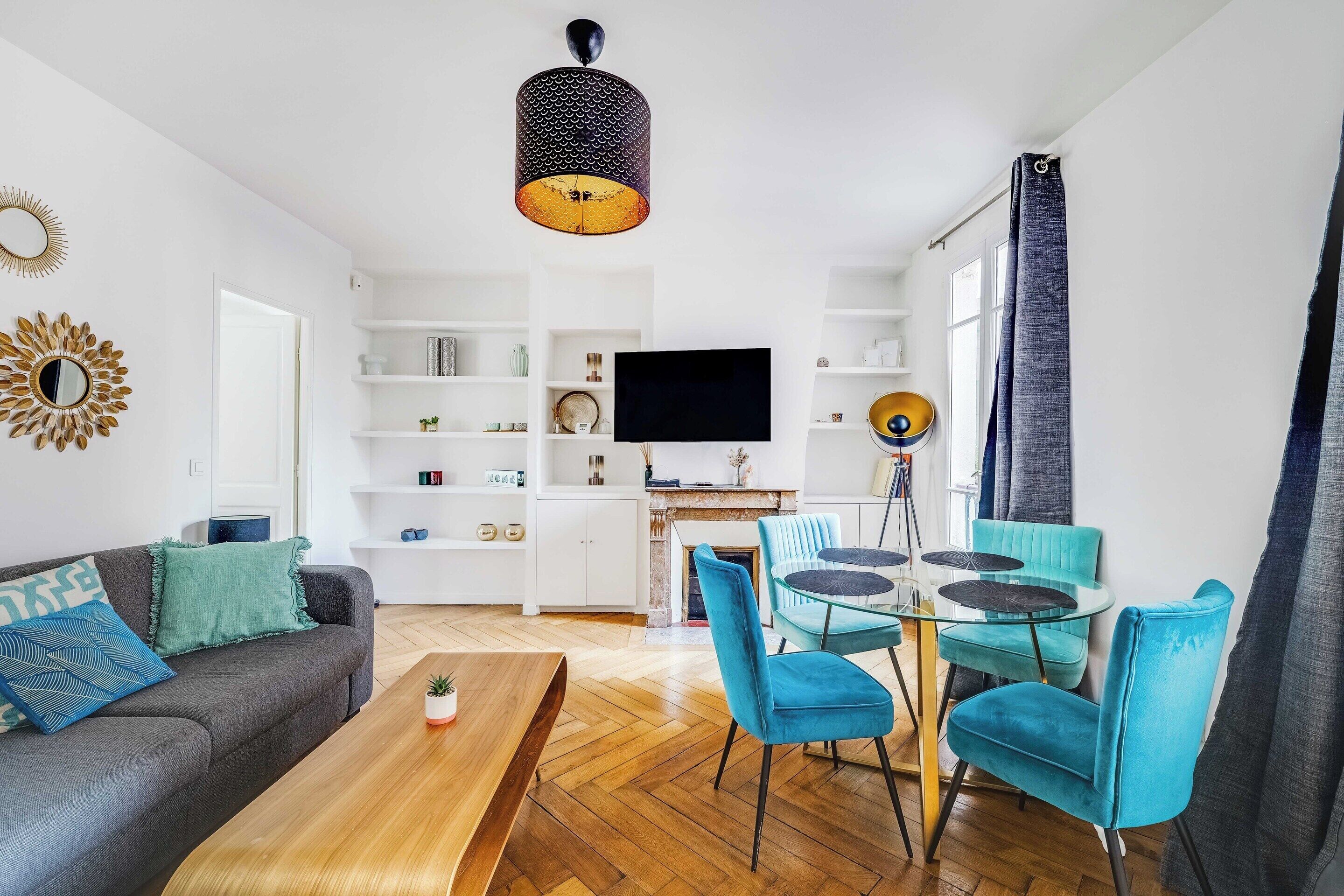Una sala de estar moderna con sofá, mesa de centro y un comedor con sillas y una mesa.