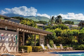 A pool area with lounge chairs, a lifeguard tower, and a view of mountains. - Wailea Ekolu 608 | Beautiful Wailea Condo with Ocean Views and Resort Amenities (Kihei)