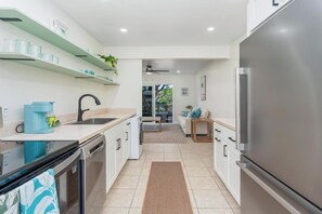 Eine moderne Küche mit Geschirrspüler, Kaffeemaschine und Kühlschrank.