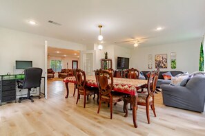 A spacious living area with a dining table, chairs, a sofa, and a TV. - Spacious 3BR DFW Family Retreat, Pet Friendly & Fenced Yard (Irving)
