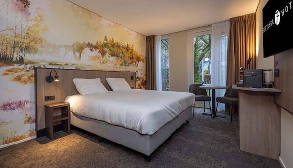 Een hotelkamer met een bed, een bureau en een televisie.