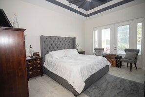 A bedroom with a large bed, a dresser, a chair, and a desk. - The Ultimate Waterfront Retreat | 5BR • Pool & Spa • Resort Amenities (Cape Coral)