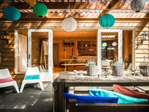 An outdoor wooden deck with a table, chairs, and potted plants. - 4 Rooms w/ Private Terrace in Forest – Nature Lover's Delight (Putten)