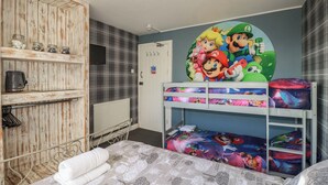 A child's bedroom with bunk beds, a wall clock, and a shelf with jars. - Shoreline Apartment No.8 (Newquay)