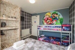 A child's bedroom with bunk beds, a wall clock, and a shelf with jars. - Shoreline Apartment No.8 (Newquay)