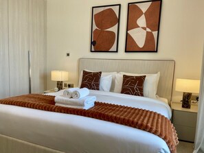 A hotel room with a large bed, two bedside lamps, and abstract artwork on the wall. - Serene Yas Island Hideaway w Resort Facilities (Abu Dhabi)
