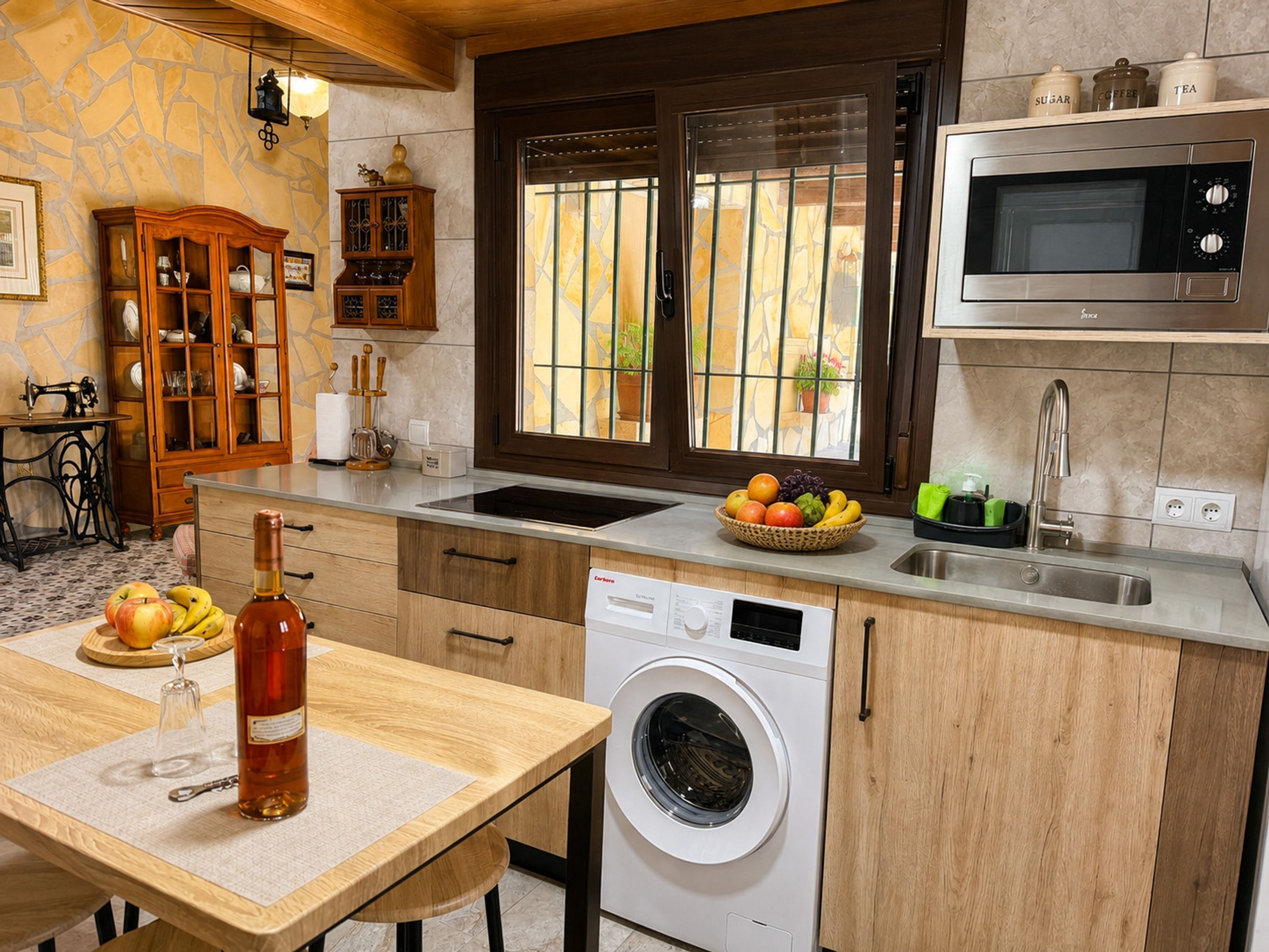 A compact kitchen with a washing machine, a microwave, and a sink.