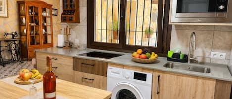 A compact kitchen with a washing machine, a microwave, and a sink.