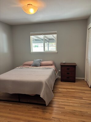 A bedroom with a bed, a nightstand, a window, and a ceiling light. - Lovely updated 3-bedroom house in quaint Cortez perfect for your getaway (Cortez)