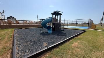 A playground with a slide and a covered play structure.